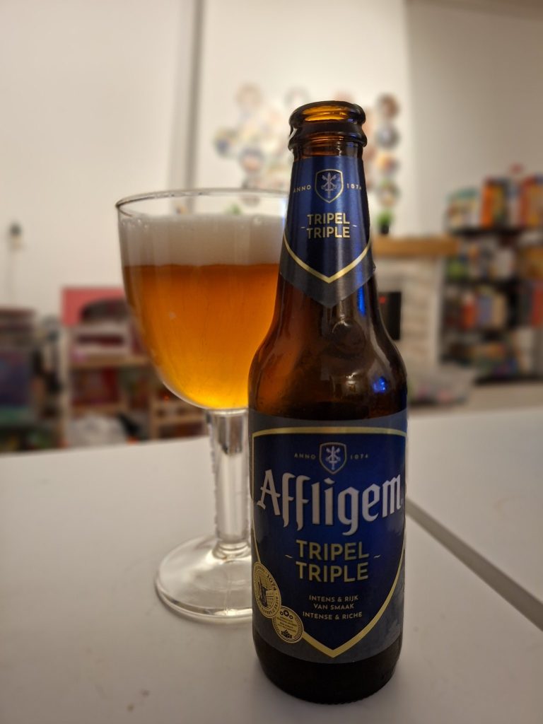 Affligem Tripel bottle and glass showing golden color and thick white foam