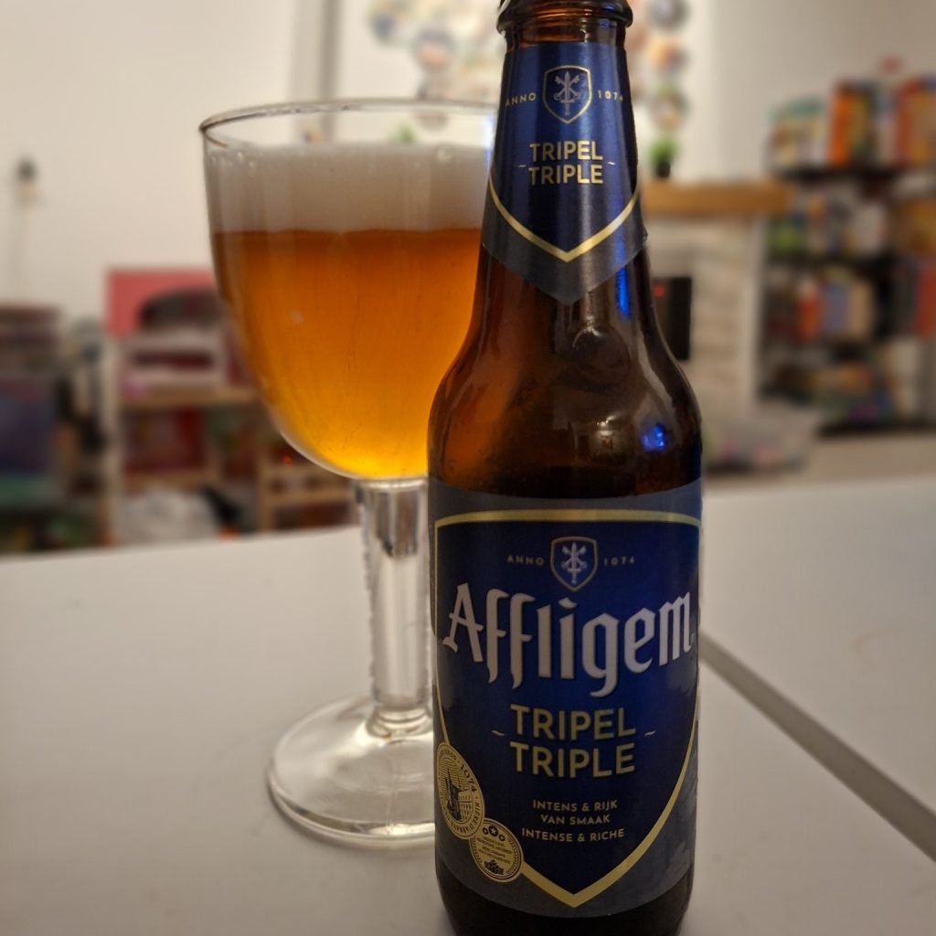 Affligem Tripel bottle and glass showing golden color and thick white foam, made for craftbeer reviews