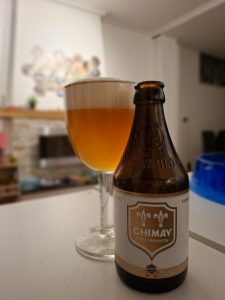 Bottle and glass of Chimay Cinq Cents Belgian Tripel with hazy golden color and frothy head