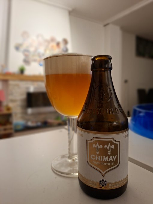 Bottle and glass of Chimay Cinq Cents Belgian Tripel with hazy golden color and frothy head